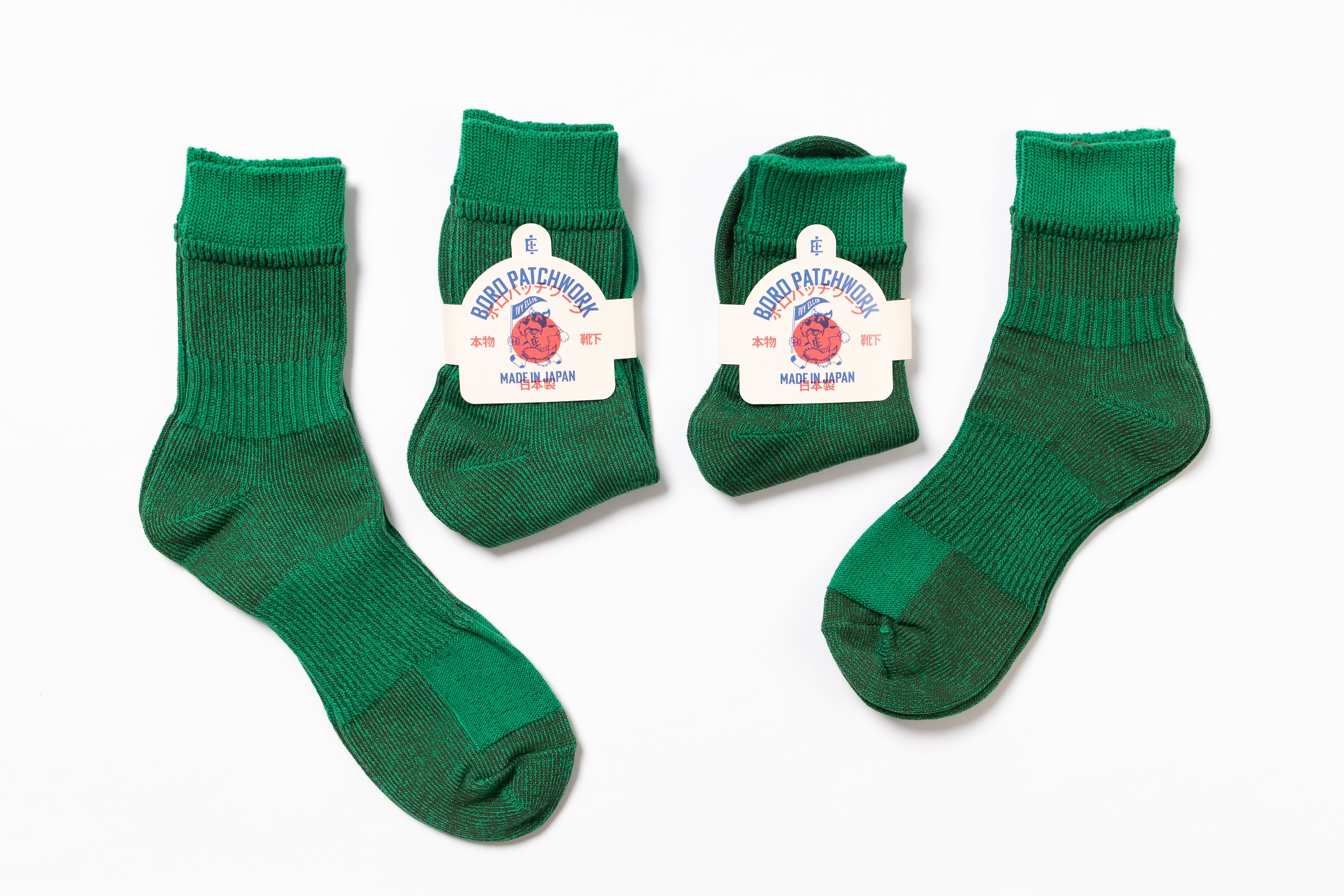 Four pairs of Green socks with labels on a white background