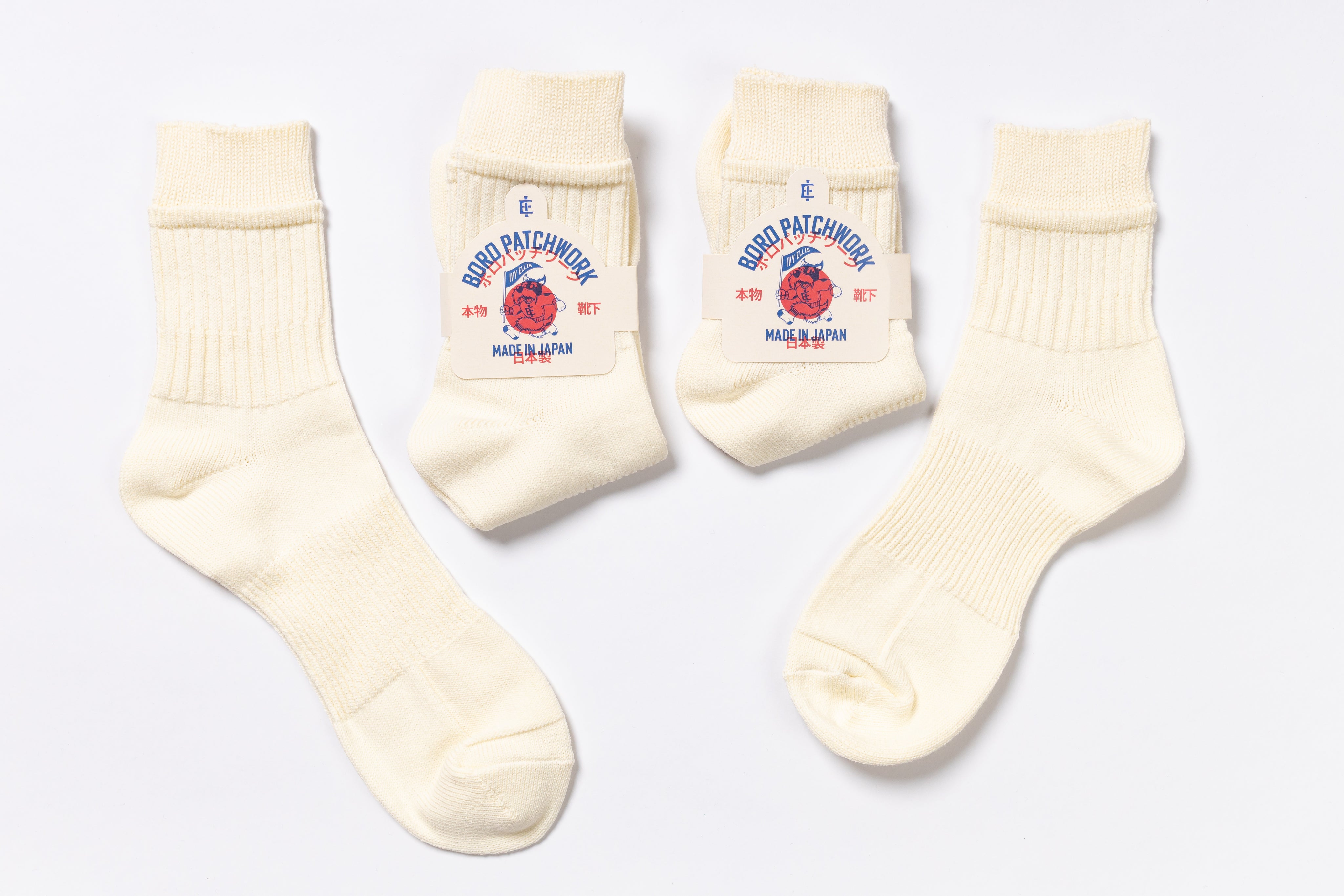 Set of cream-colored socks with brand logo on a light gray background