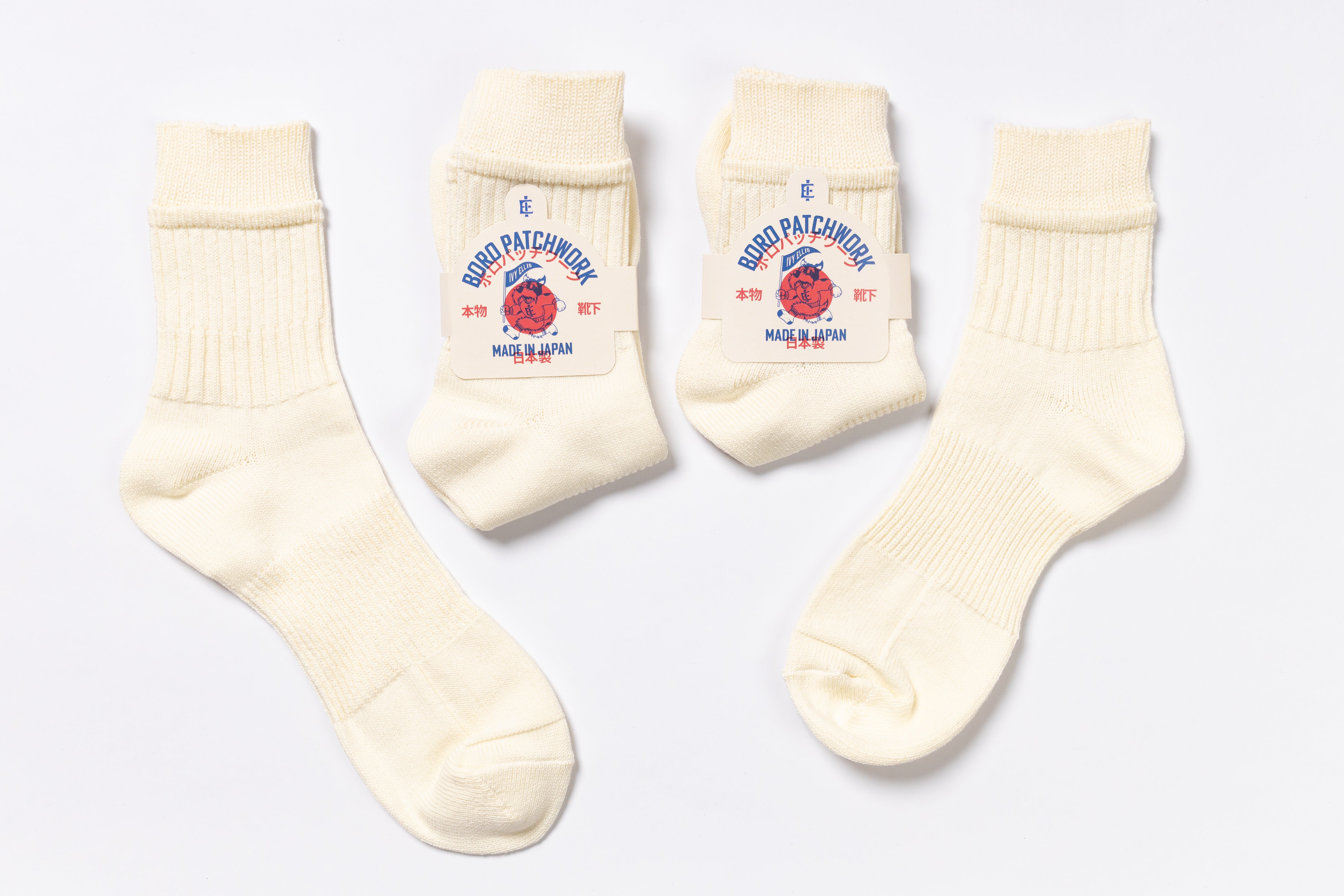 Set of cream-colored socks with brand logo on a light gray background