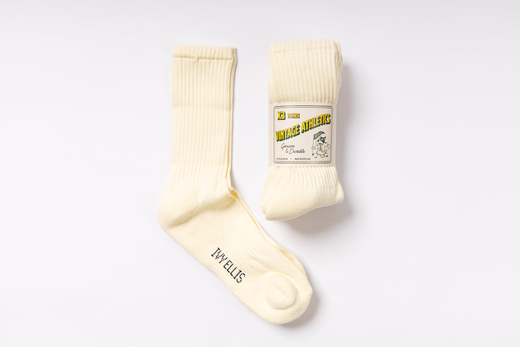 Pair of cream-colored socks with a label on a white background