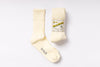 Pair of cream-colored socks with a label on a white background