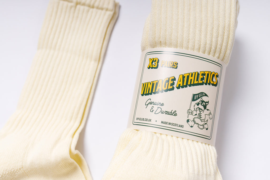 Pair of cream-colored socks with a 'Vintage Athletics' label on a white background