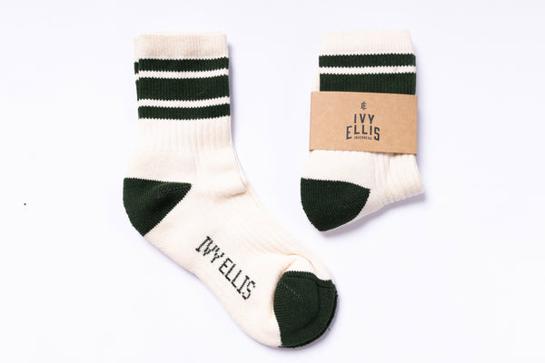 Pair of white socks with green stripes and cuffs, featuring 'Ivy Ellis' branding, on a white background.