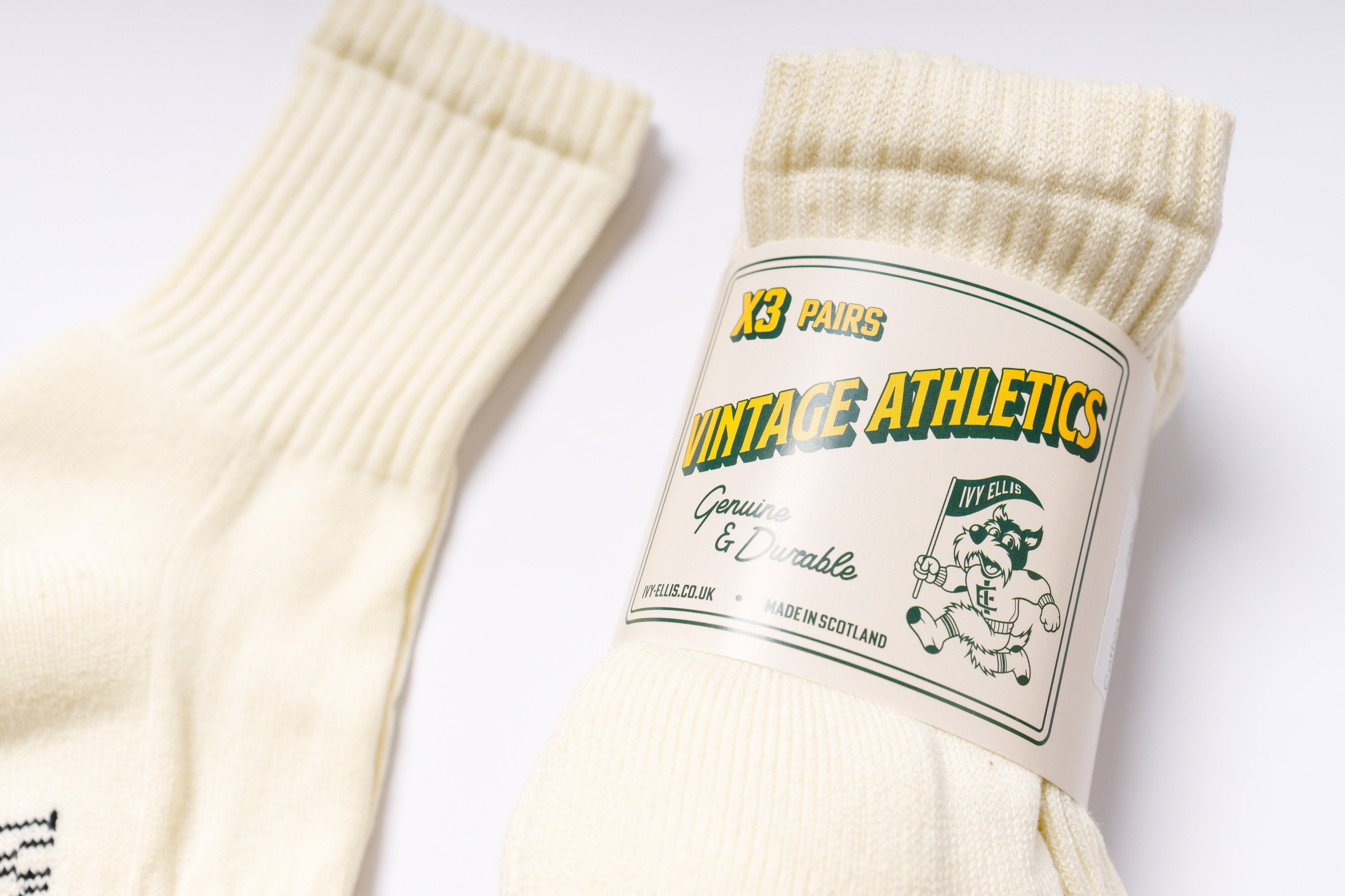 Pair of cream socks with a 'Vintage Athletics' label on a white background