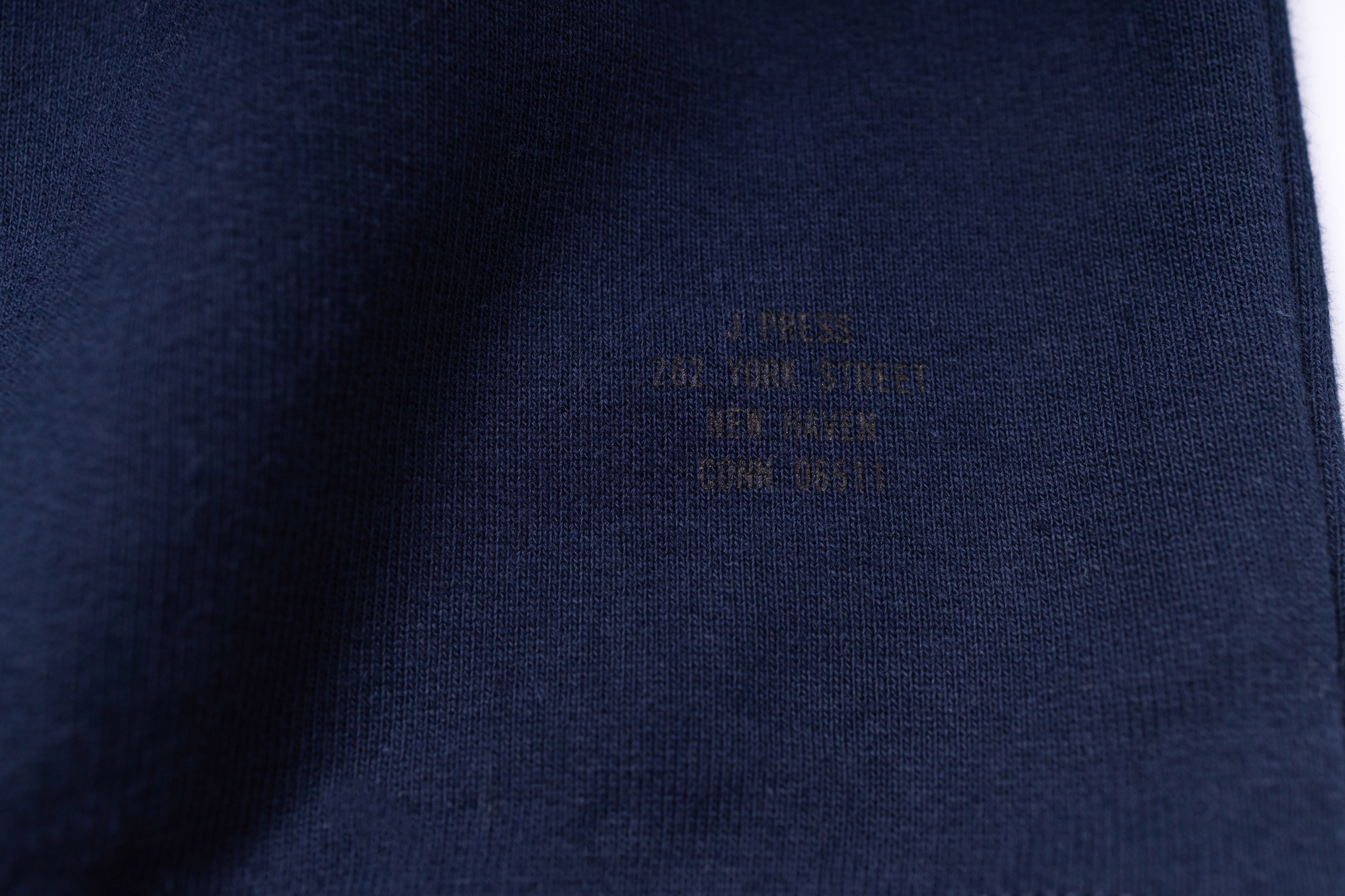 Close-up of a navy blue fabric with embroidered text on a white background