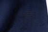 Close-up of a navy blue fabric with embroidered text on a white background