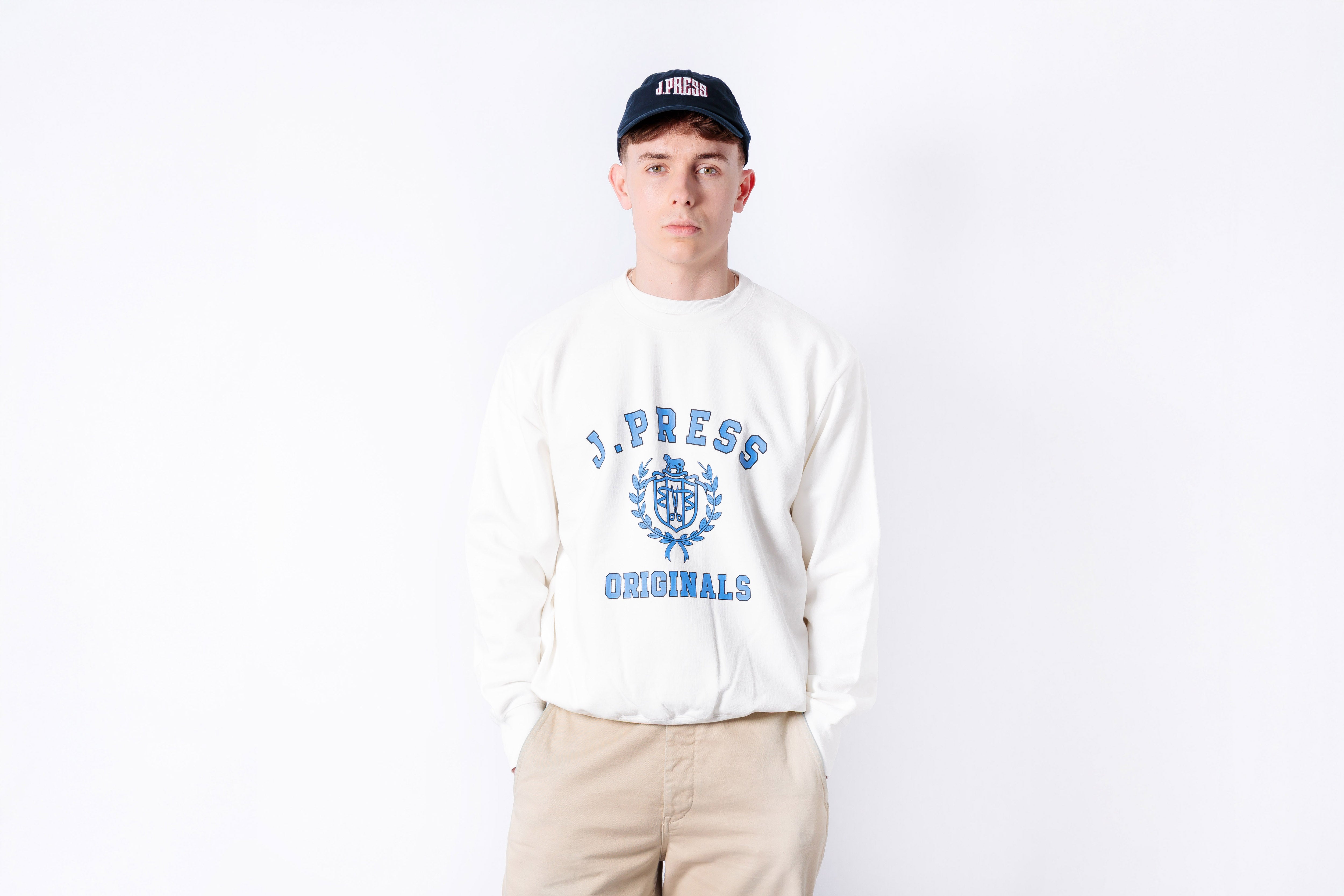 Person wearing a white sweatshirt with blue text and graphics on a white background