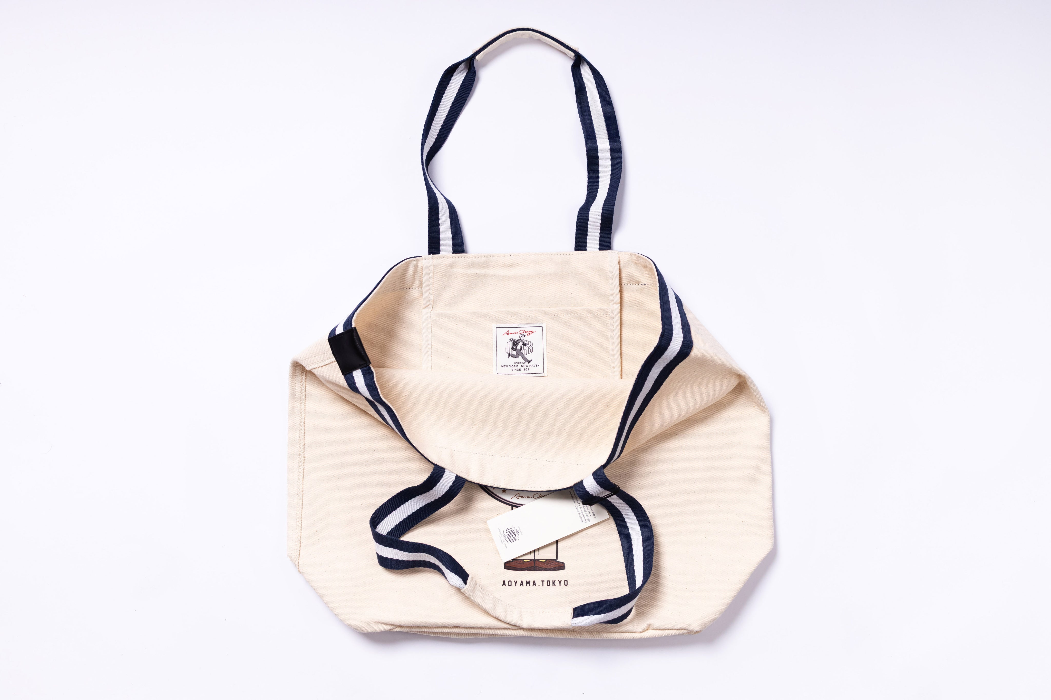 Beige tote bag with navy accents on a white background