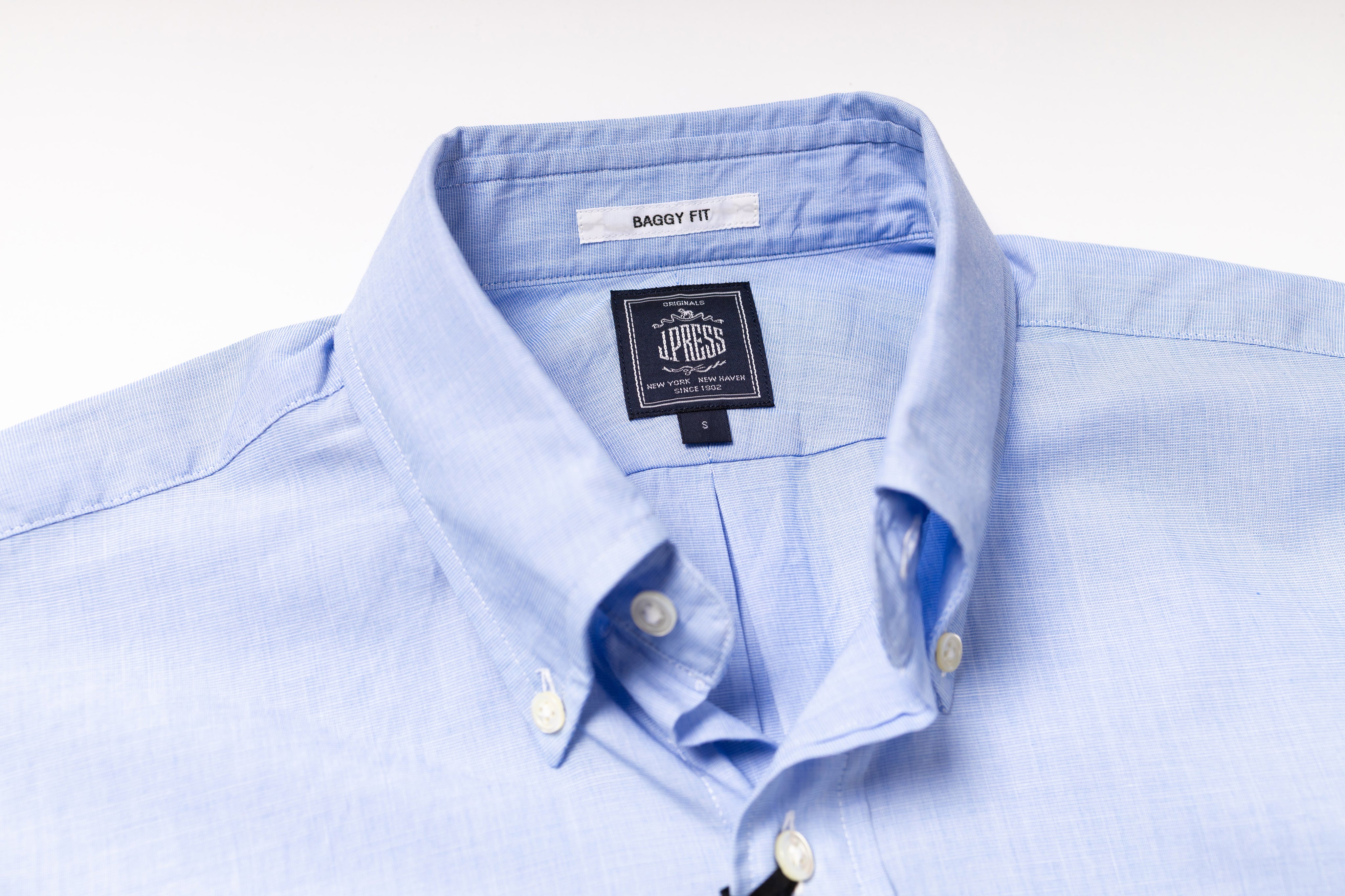 Light blue dress shirt with a brand label on a white background