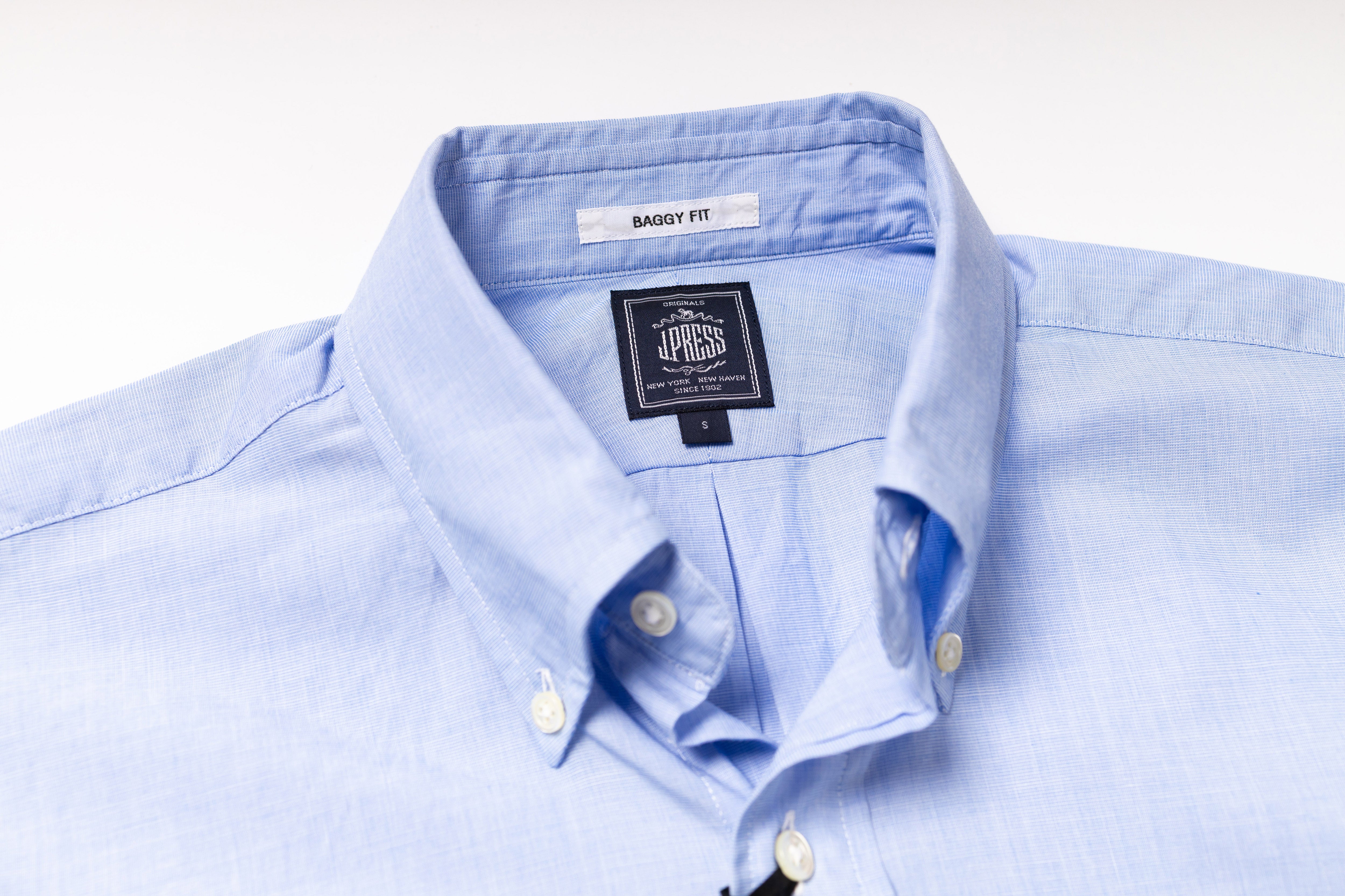 Light blue dress shirt with a brand label on a white background