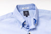 Light blue dress shirt with a brand label on a white background