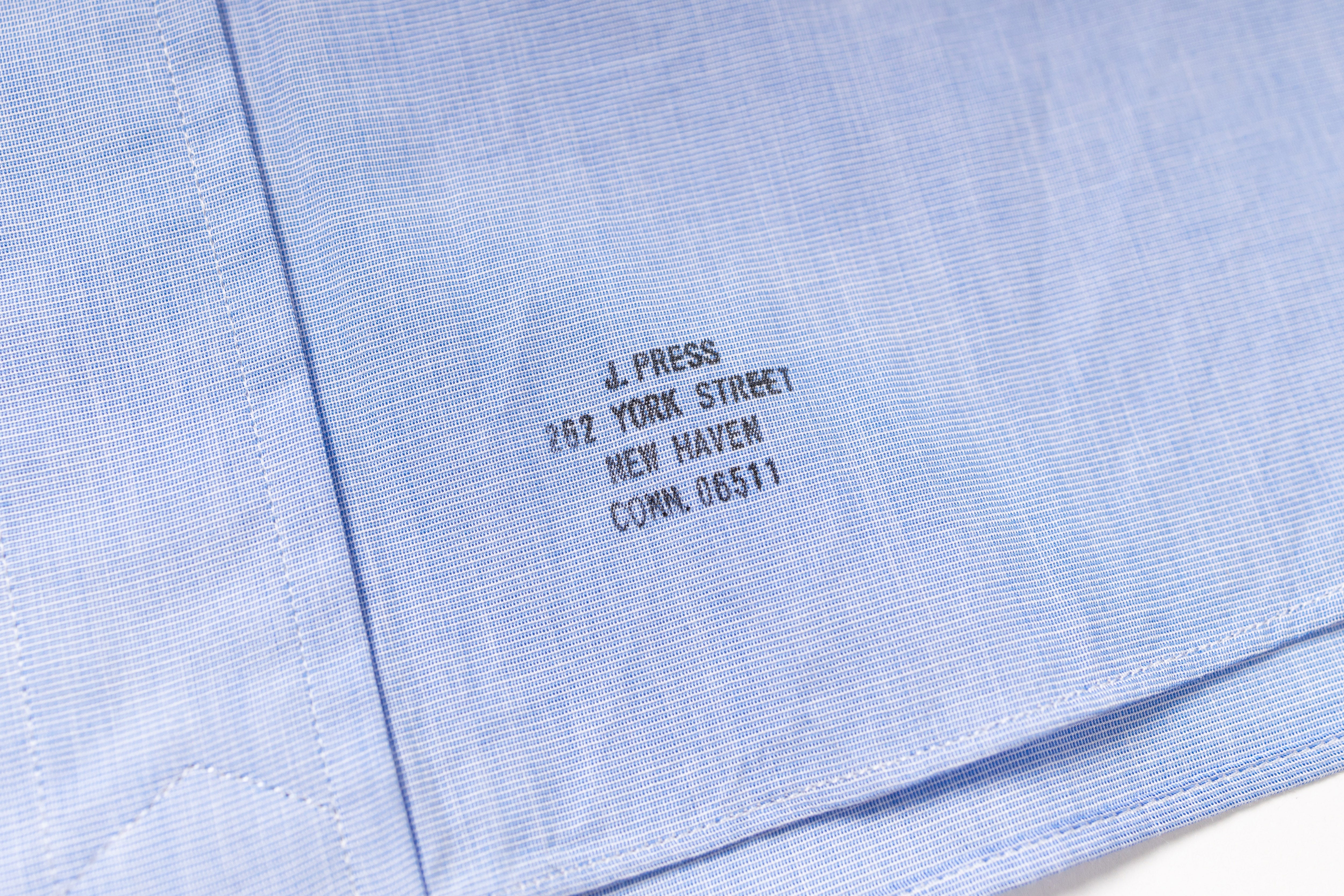 Embroidered text on a light blue fabric background