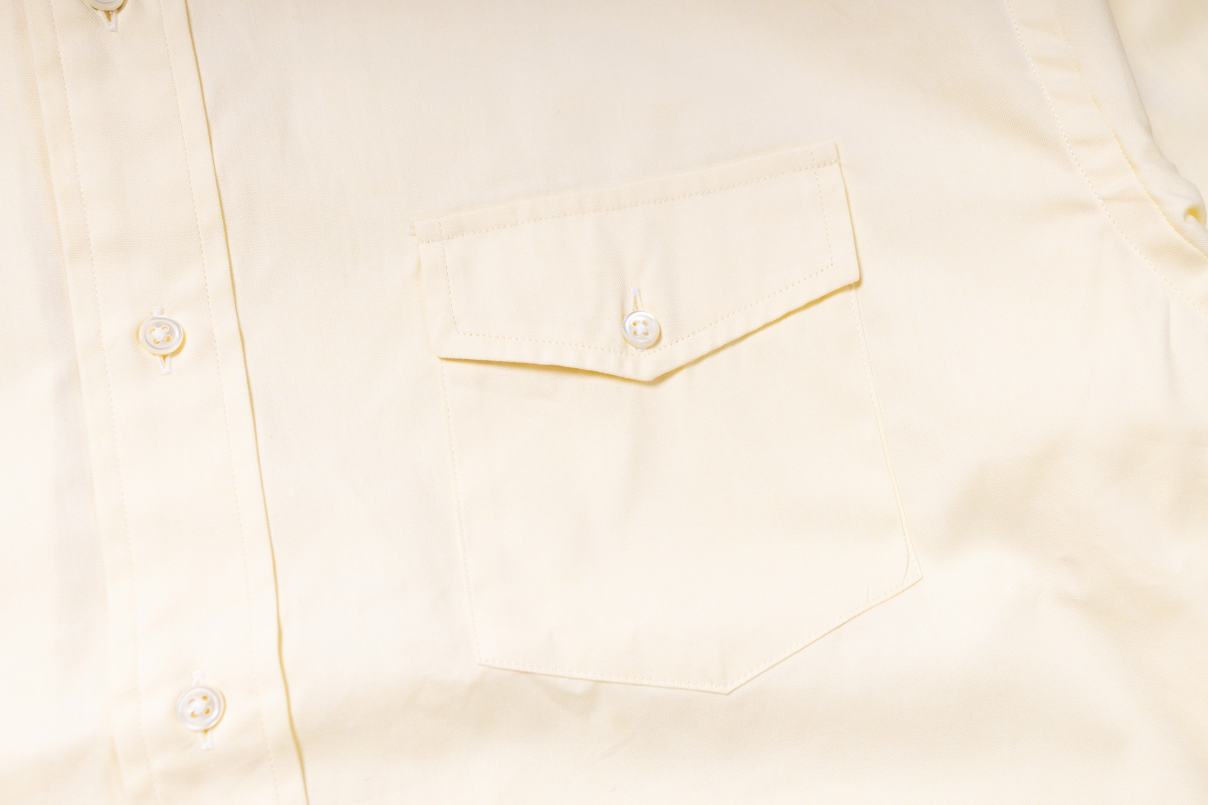 Close-up of a light-colored shirt with a pocket detail