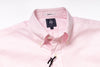Close-up of a pink shirt with a brand label on a white background