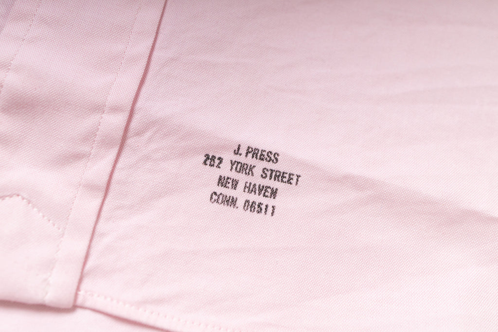 Pink fabric with embroidered text on a light pink background