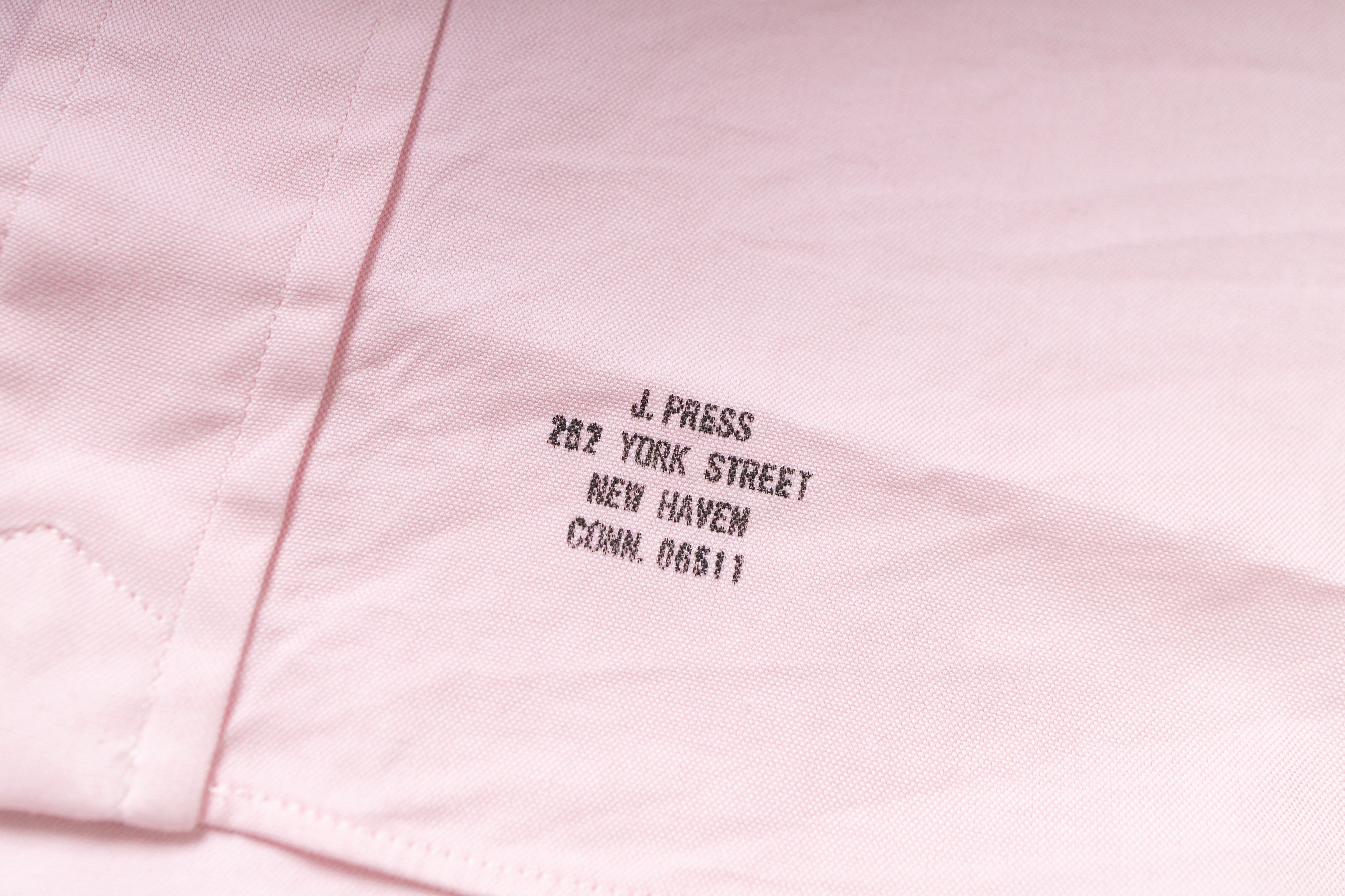 Pink fabric with embroidered text on a light pink background