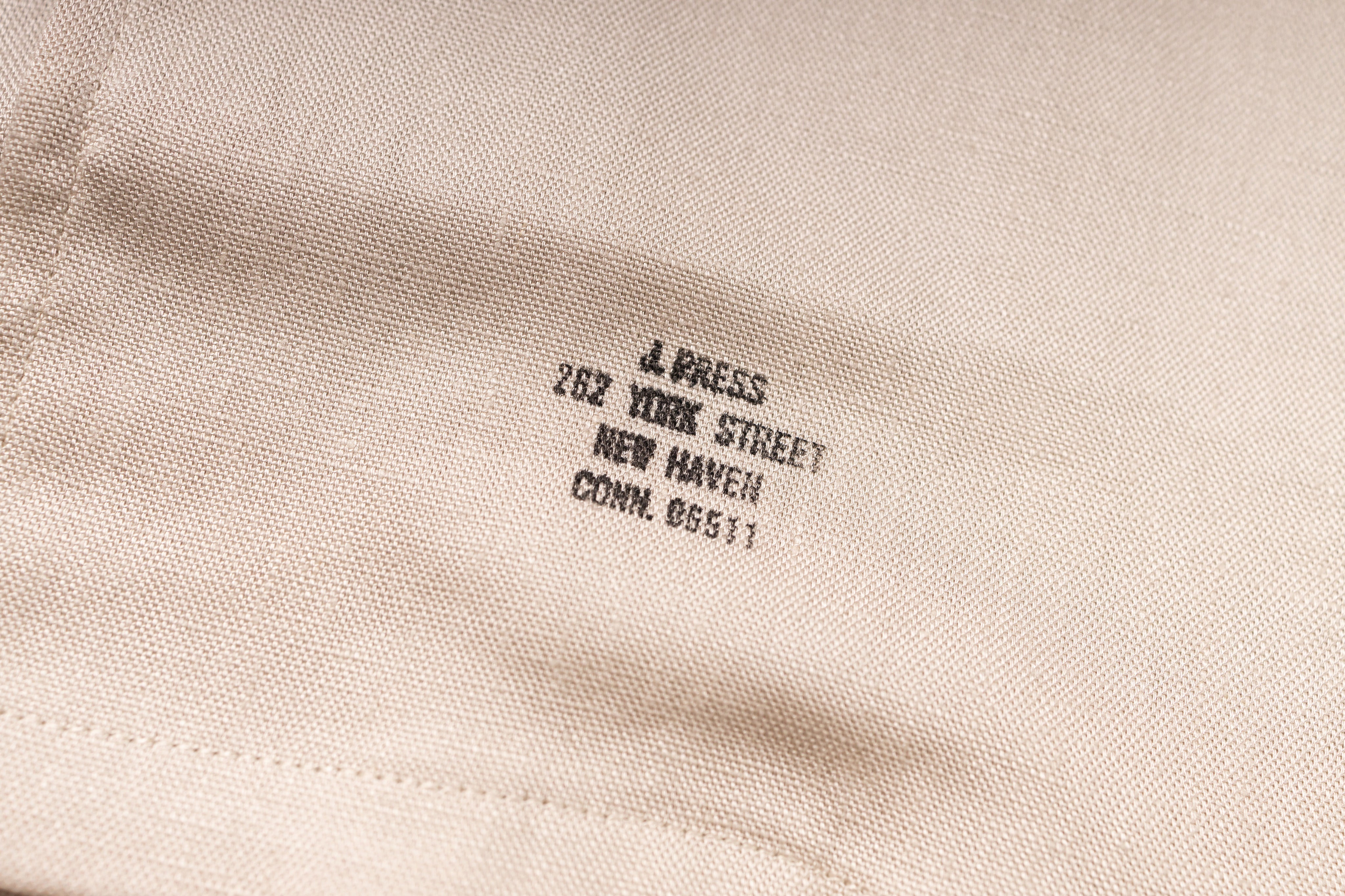 Embroidered label on a beige fabric with text