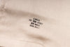 Embroidered label on a beige fabric with text