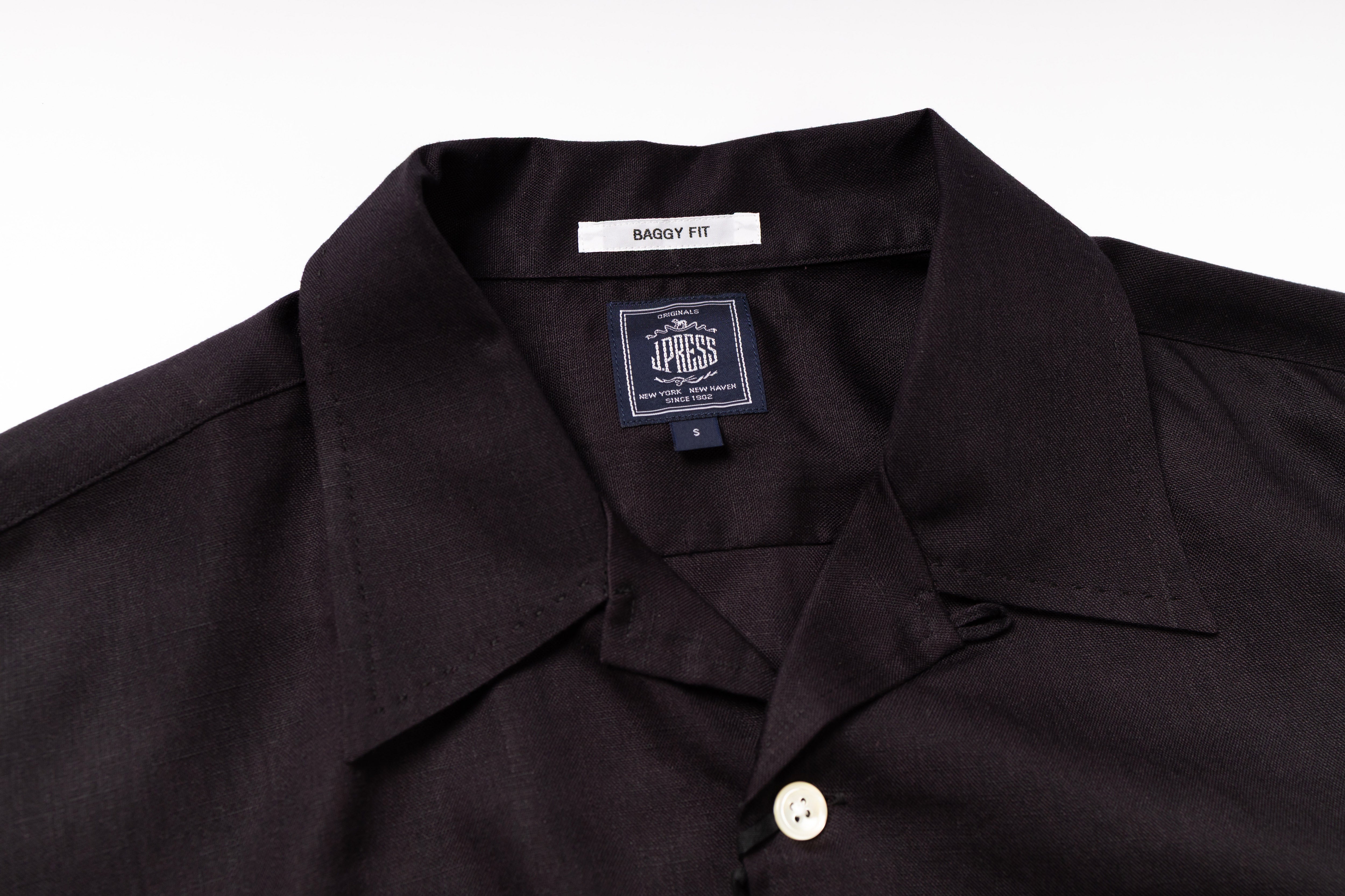 Close-up of a black shirt with a label on a white background