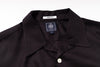 Close-up of a black shirt with a label on a white background