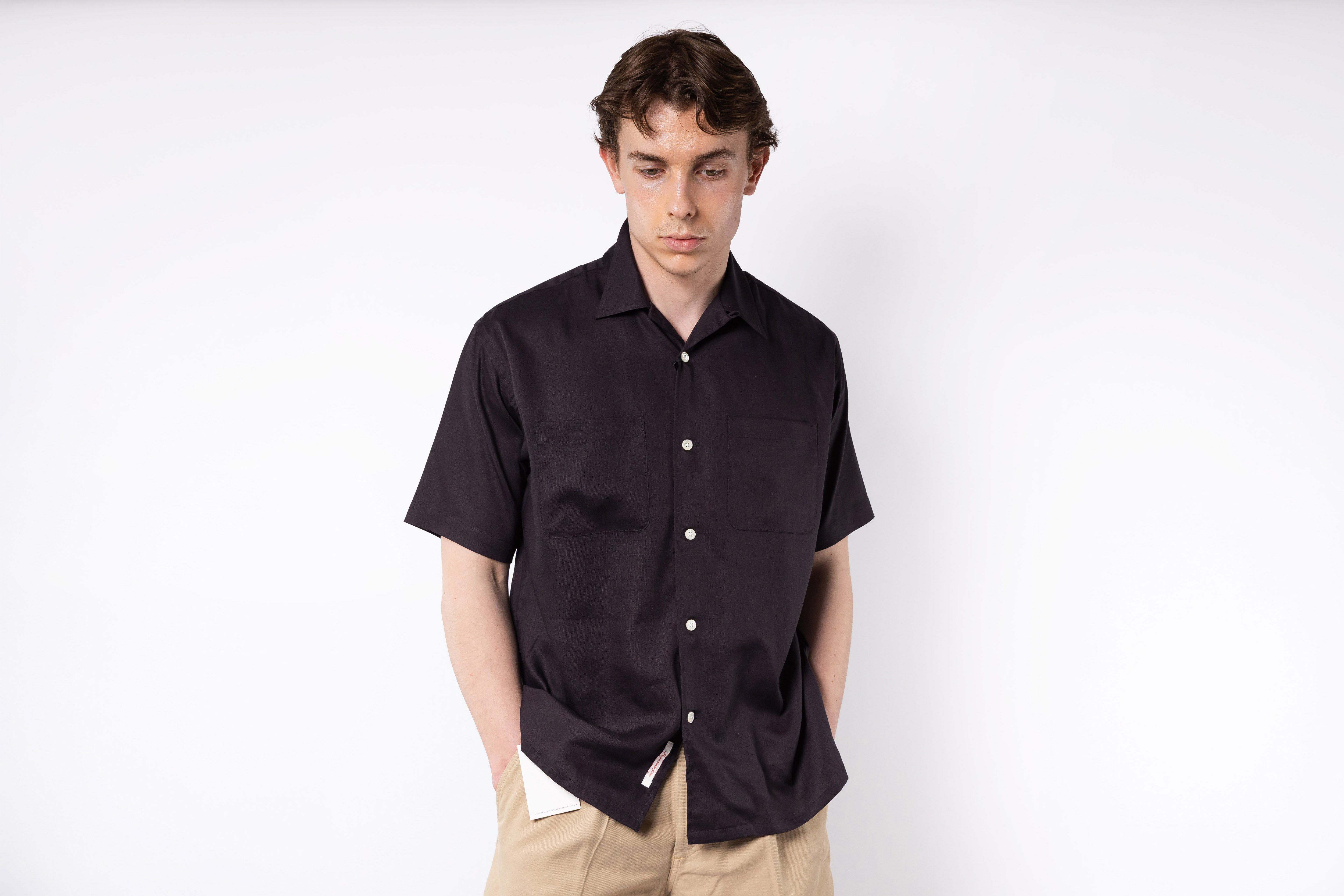 Man wearing a black short-sleeve shirt on a white background