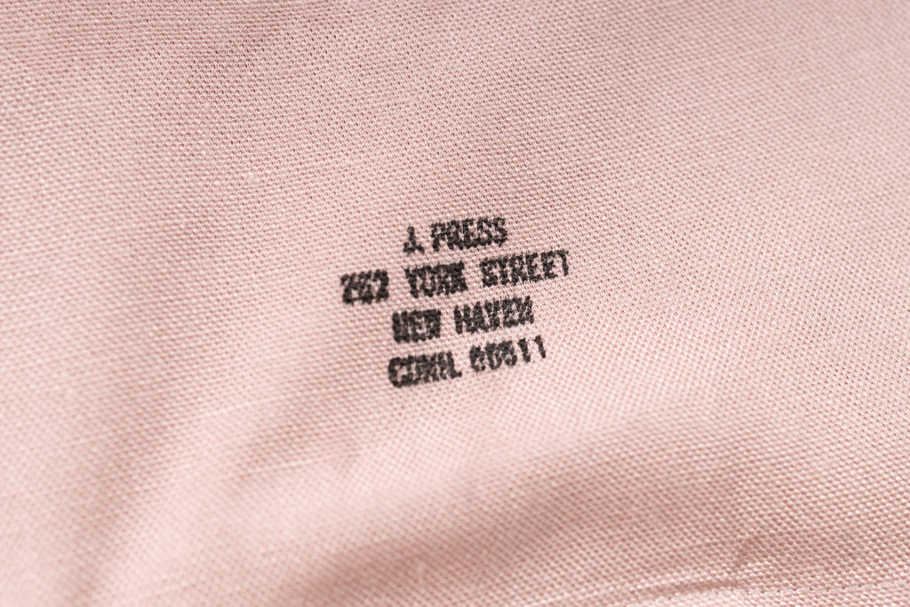Embroidered text on a pink fabric background