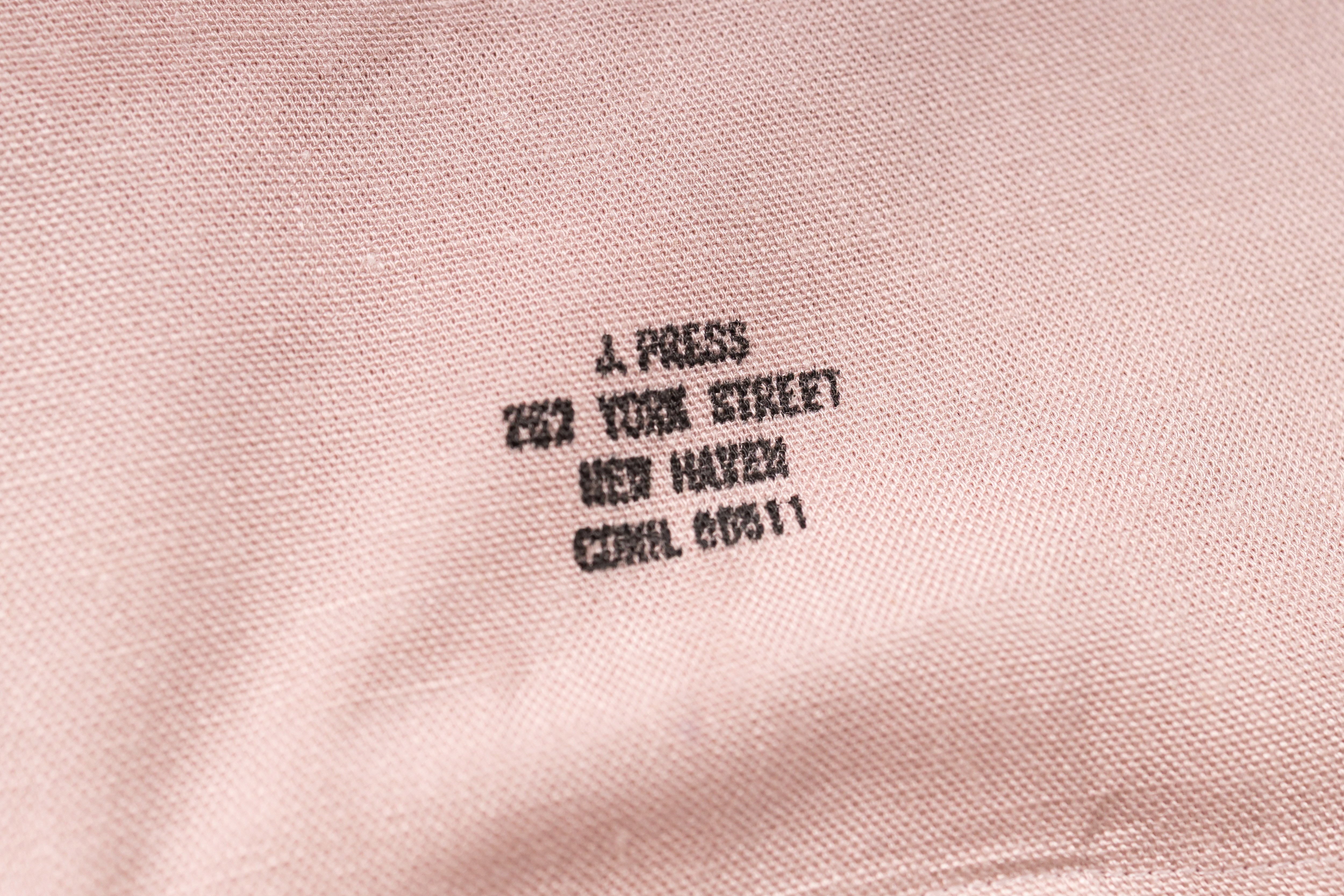 Embroidered text on a pink fabric background