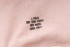 Embroidered text on a pink fabric background