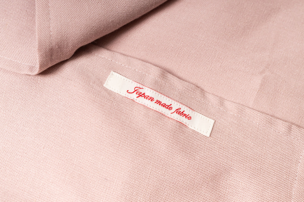 Label on pink fabric indicating 'Japanese made fabric' with a soft focus background.