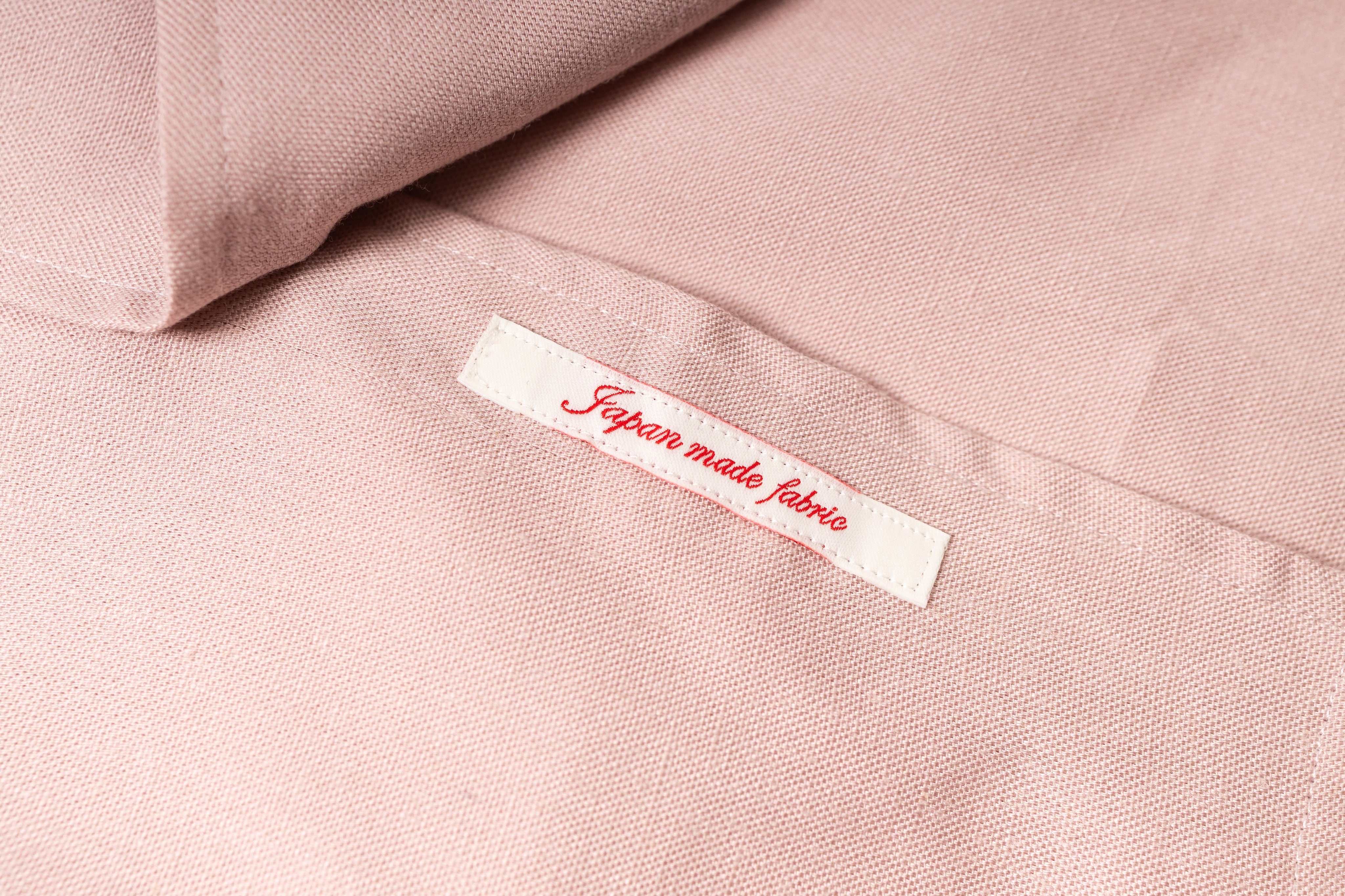 Label on pink fabric indicating 'Japanese made fabric' with a soft focus background.