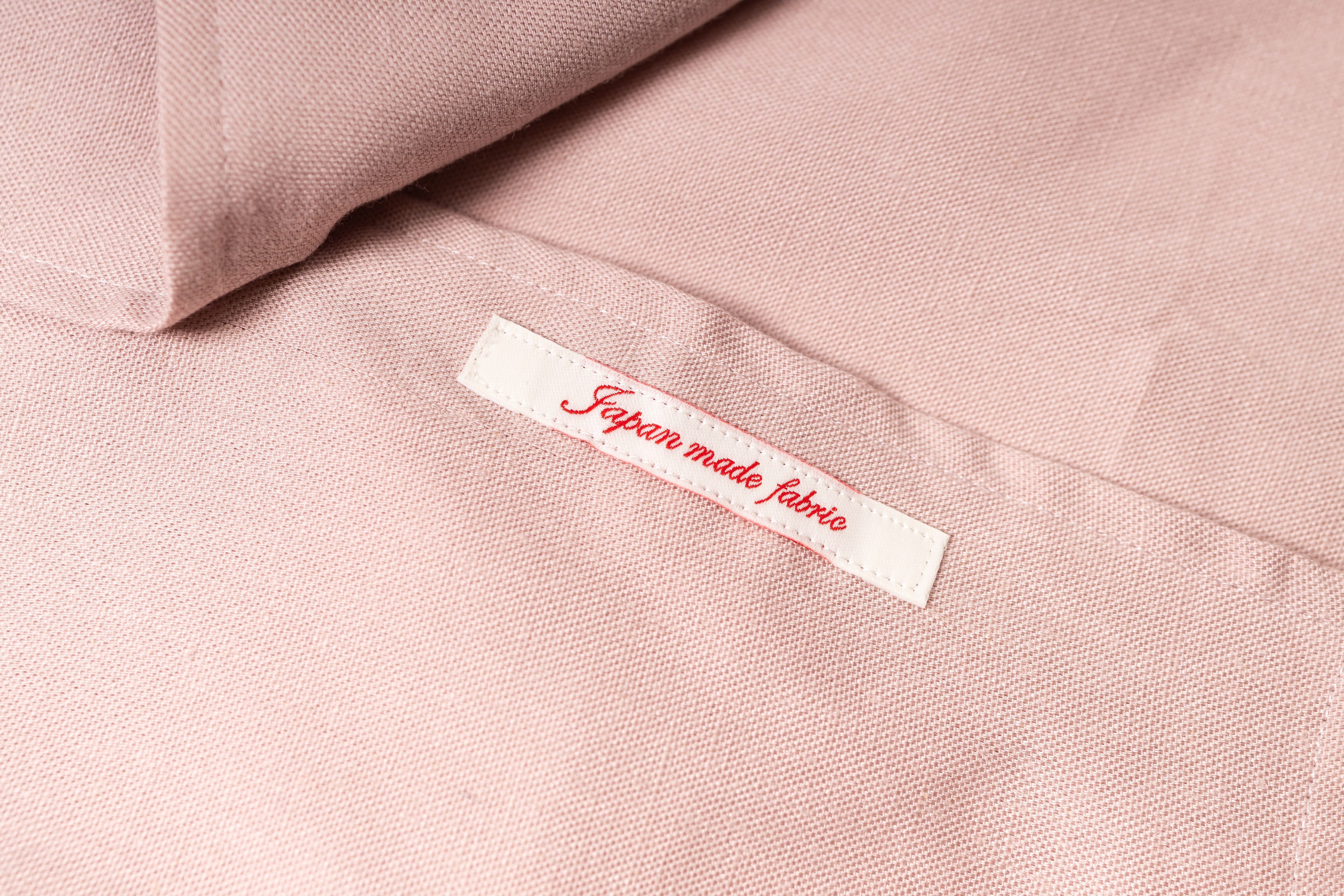 Label on pink fabric indicating 'Japanese made fabric' with a soft focus background.