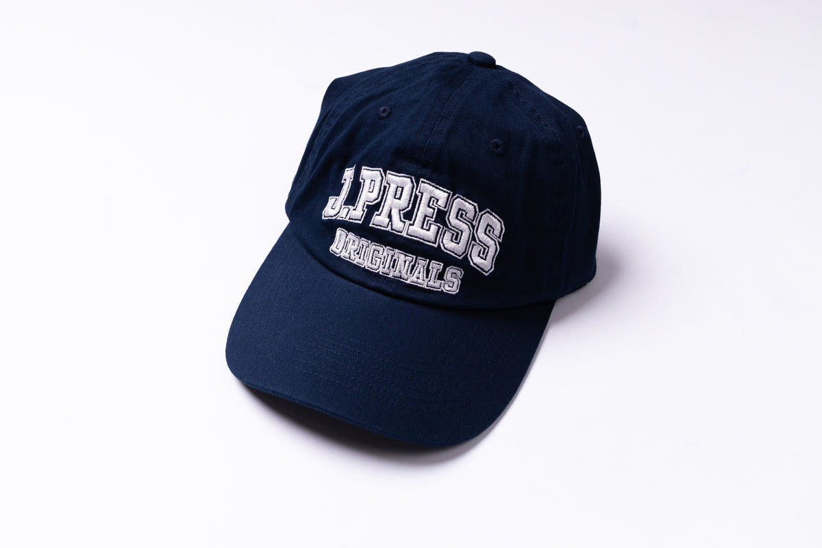 A navy blue baseball cap with 'J-Press Originals' embroidered in white on the front, photographed on a clean white background.