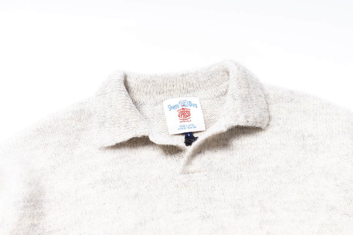 Close-up of a white fleece collar with a brand label on a white background