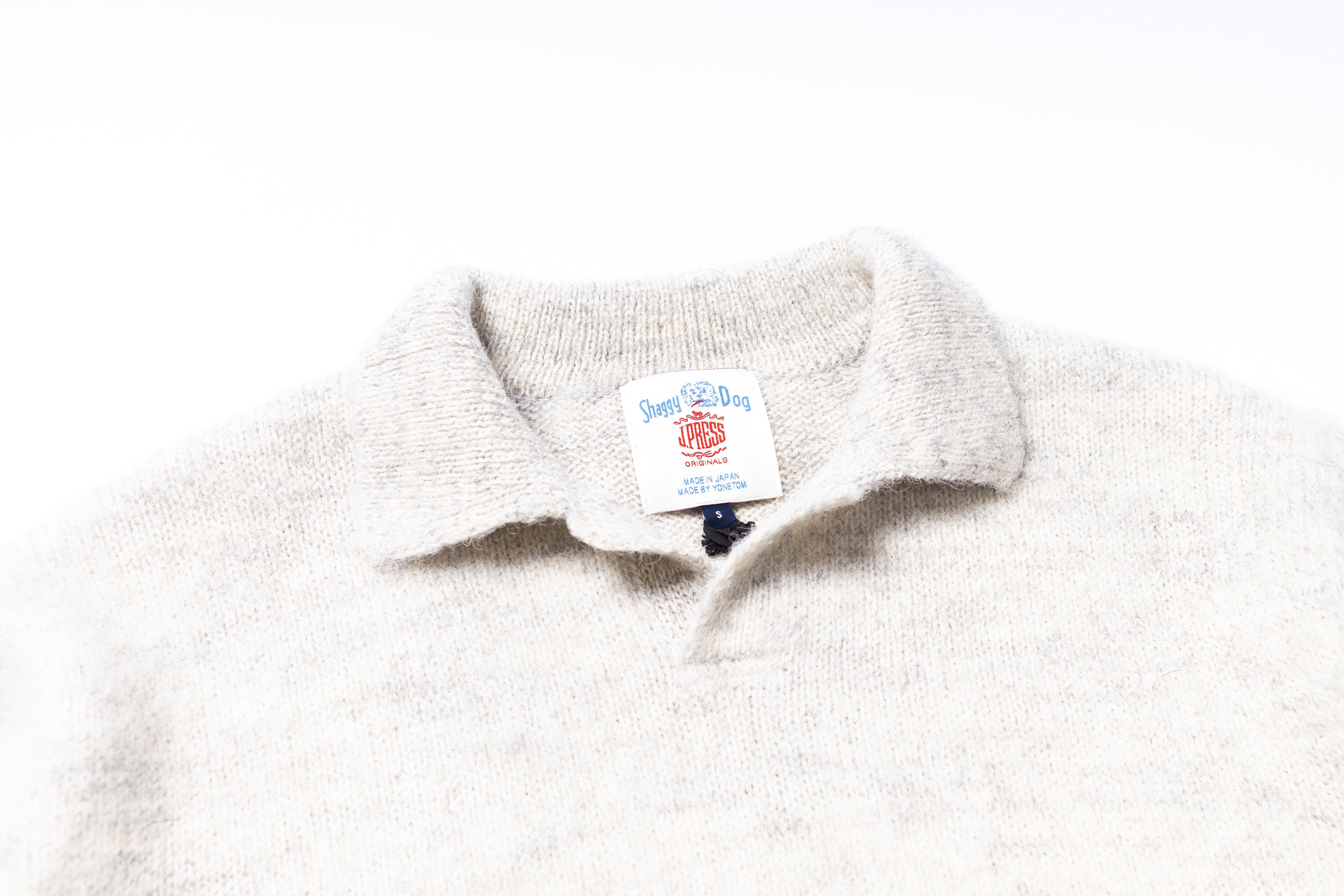 Close-up of a white fleece collar with a brand label on a white background