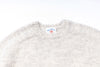Gray sweater with a brand label on a white background