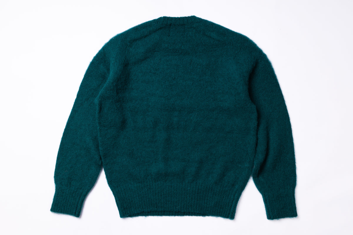 A dark teal green knit sweater shown from the back, laid flat against a clean white background.