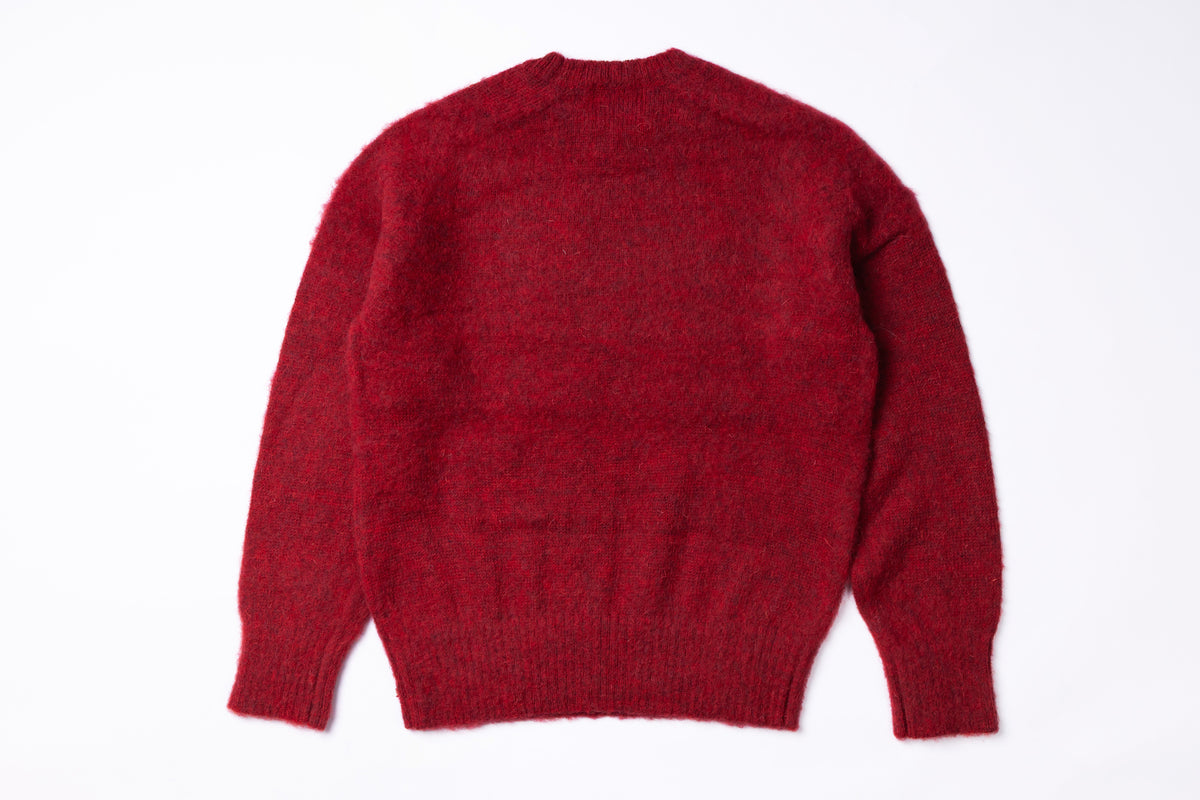 A red knit sweater shown from the back, laid flat against a plain white background.