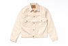 A light beige denim trucker jacket with a button-up front, two buttoned chest flap pockets, and a classic collar, laid flat on a white background.