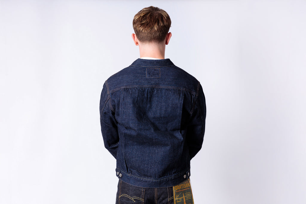 Person wearing a blue denim jacket on a white background