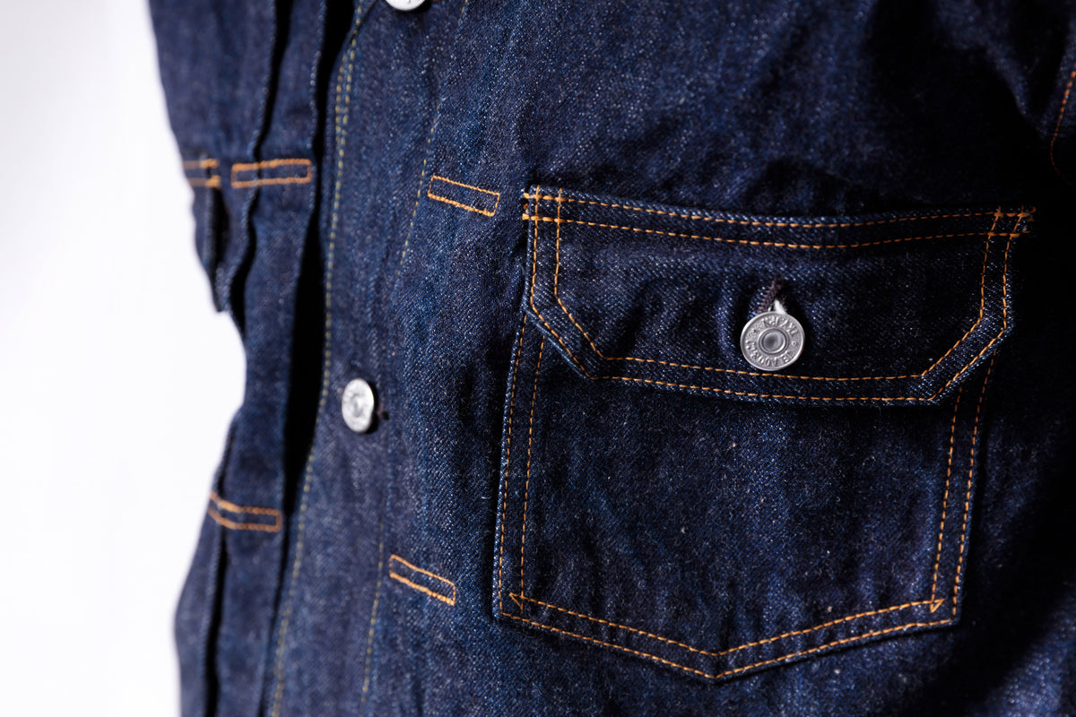 Close-up of a dark blue denim jacket with buttons and stitching details.