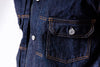 Close-up of a dark blue denim jacket with buttons and stitching details.