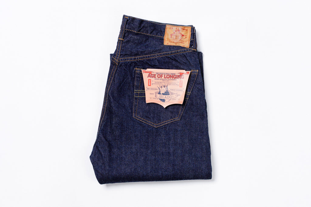 Folded pair of blue jeans with a brand label on a white background