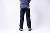 Person wearing dark blue jeans and a purple shirt on a white background
