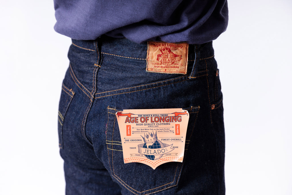 Blue jeans with visible brand labels on a white background