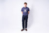 Person wearing a navy blue 'O.V.A' t-shirt and dark pants on a white background
