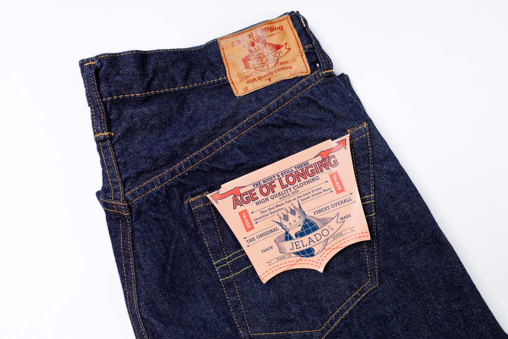 Blue jeans with a label on the pocket against a white background
