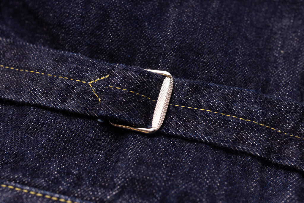 Close-up of a denim belt with a buckle on a dark denim background