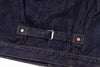 Close-up of a dark blue denim jacket with a buckle on a white background
