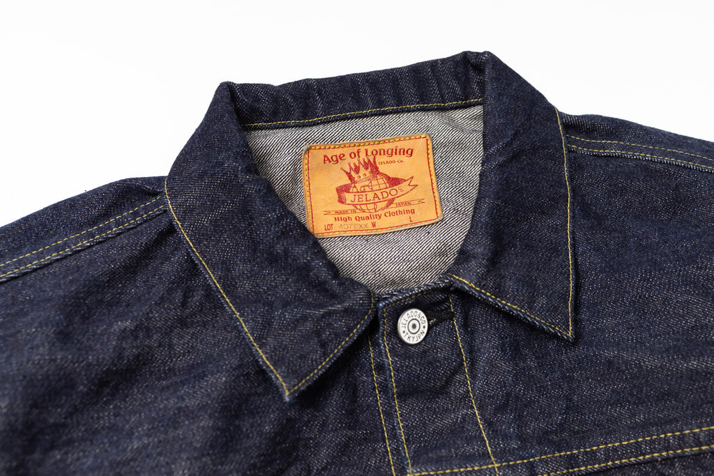 Close-up of a denim shirt collar with a brand label on a white background