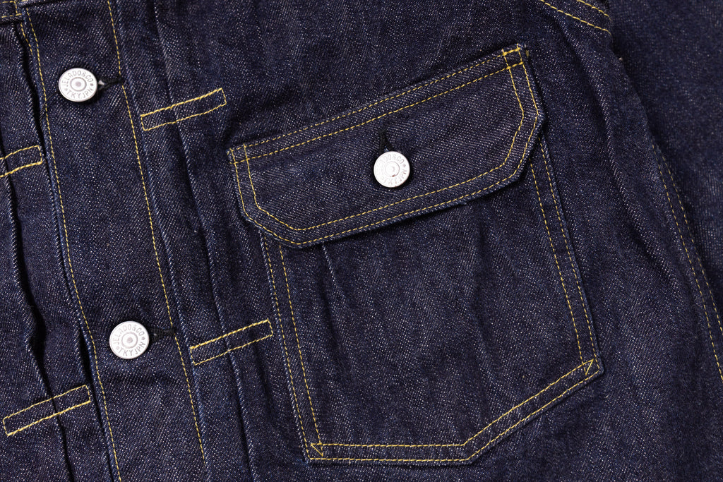 Close-up of a dark blue denim jacket with button details